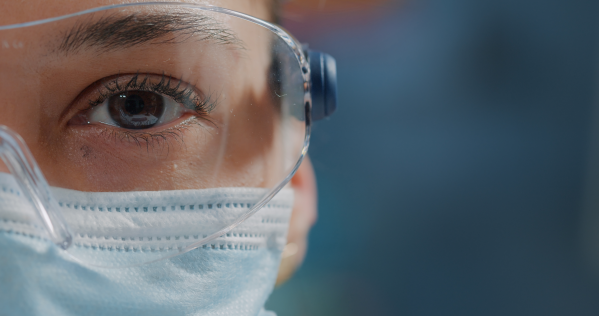 Photo of a person wearing safety glasses and a face mask, representing a team member at Wheeler's CDMO and process development facility